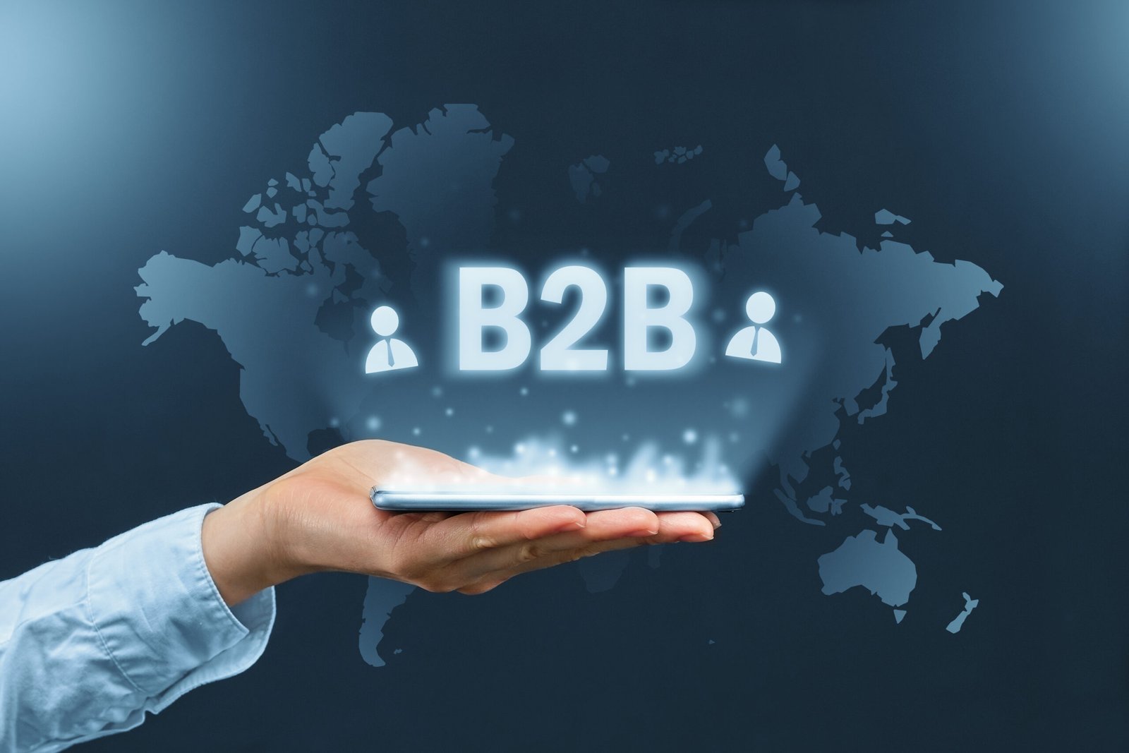 B2b concept. Business to Business graphic inscription over the smartphone on the background of the world map.